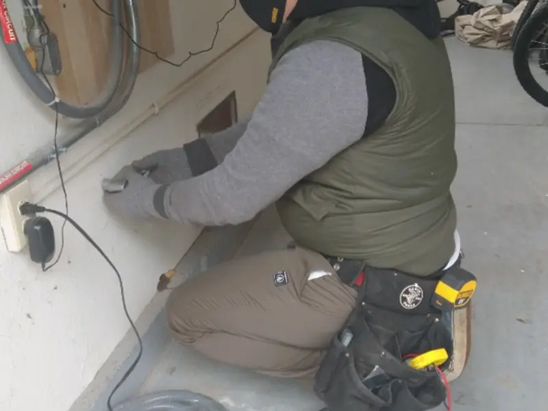 Electrician performing outlet wiring in a Shelley garage